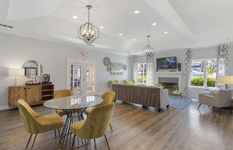 A modern dining room with a glass table and yellow chairs at The Onyx Hoover Apartments, Alabama
