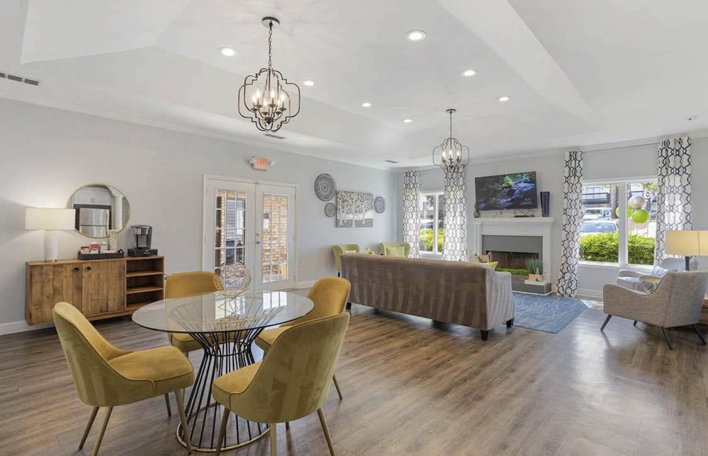 A modern dining room with a glass table and yellow chairs. A modern dining room with a glass table and yellow chairs at The Onyx Hoover Apartments, Alabama