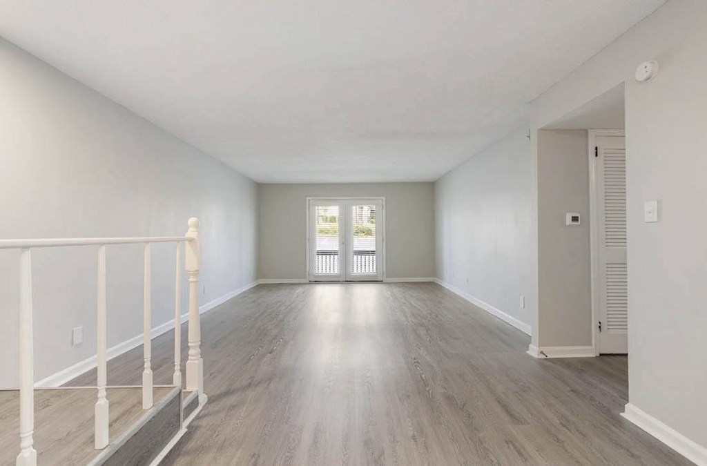 A spacious room with light wood flooring and white walls. A spacious room with light wood flooring and white walls. at The Onyx Hoover Apartments, Hoover, AL, 35216