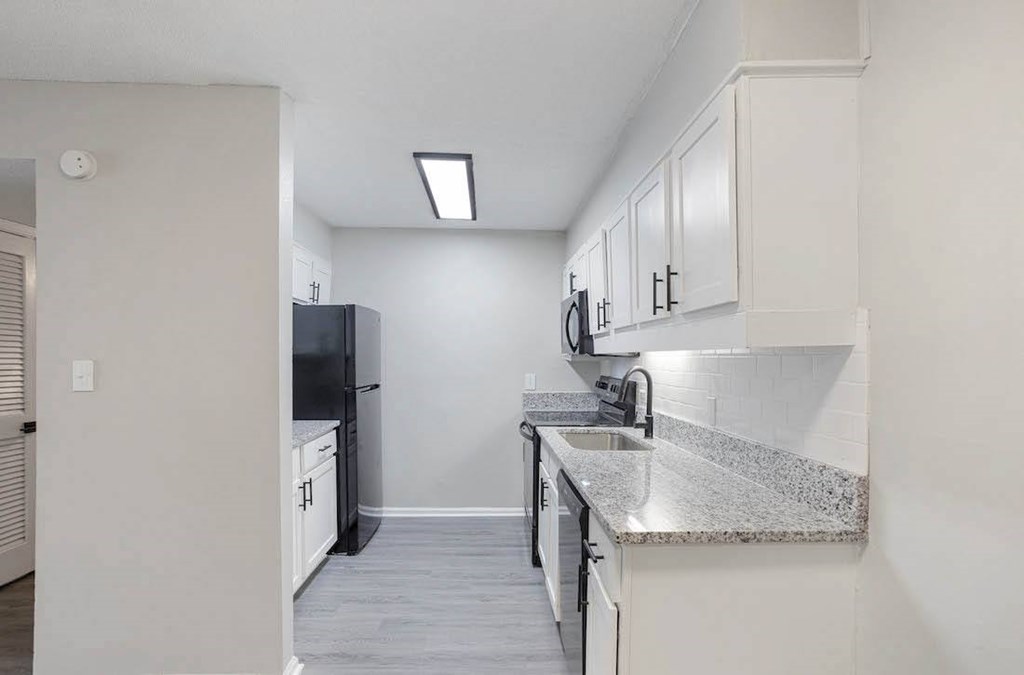 A kitchen with white cabinets and a black refrigerator. A kitchen with white cabinets and a black refrigerator at The Onyx Hoover Apartments, Alabama