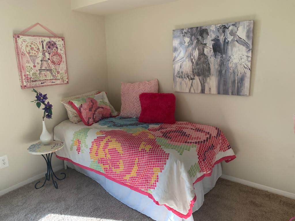 a bedroom with a bed and a painting on the wall
