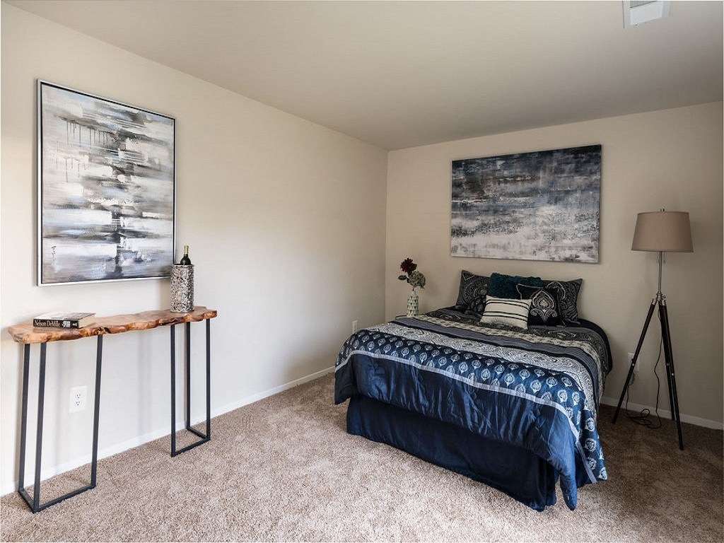a bedroom with a bed and two paintings on the wall at The Glendale Residence, Lanham, MD, 20706