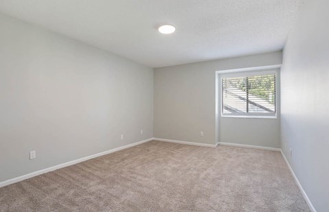 A room with a carpeted floor and a window with blinds at The Onyx Hoover Apartments, Hoover, 35216