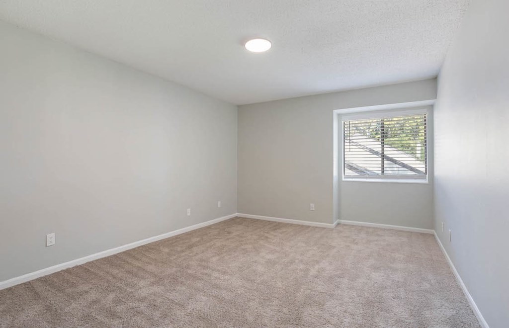 A room with a carpeted floor and a window with blinds. A room with a carpeted floor and a window with blinds at The Onyx Hoover Apartments, Hoover, 35216