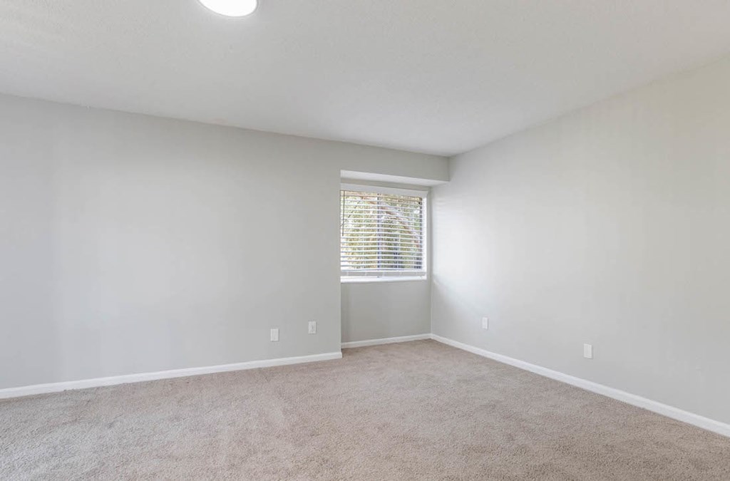 A room with a window covered by blinds and carpet on the floor. A room with a window covered by blinds and carpet on the floor at The Onyx Hoover Apartments, Hoover