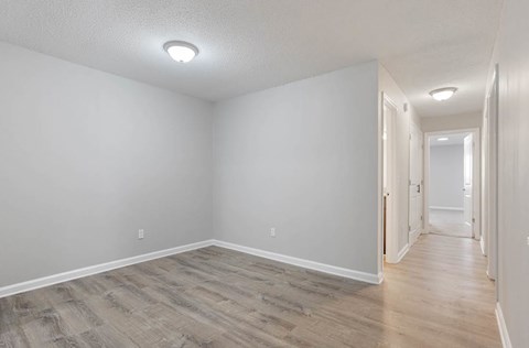 A long hallway with wood floors and white walls. at The Onyx Hoover Apartments, Hoover, Alabama