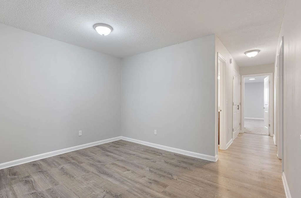 A long hallway with wood floors and white walls. A long hallway with wood floors and white walls. at The Onyx Hoover Apartments, Hoover, Alabama