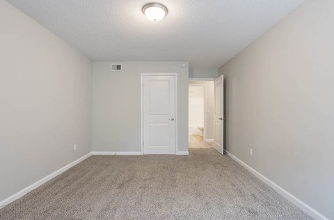 A room with a white door and carpeted floor at The Onyx Hoover Apartments, Alabama