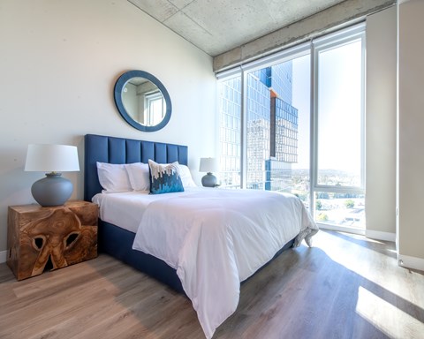 A bedroom with a large bed and a view of the city.