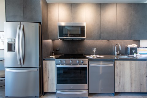 A modern kitchen with a stainless steel refrigerator, oven, and microwave.