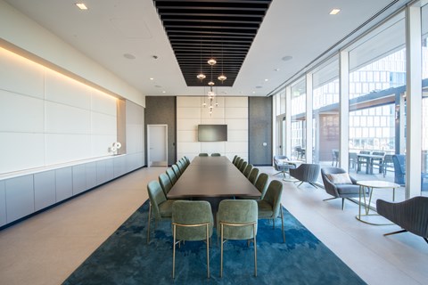 A conference room with a long table and chairs.
