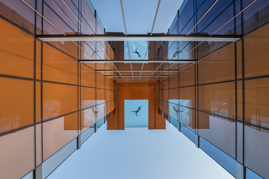 A modern hallway with orange walls and a wooden door.