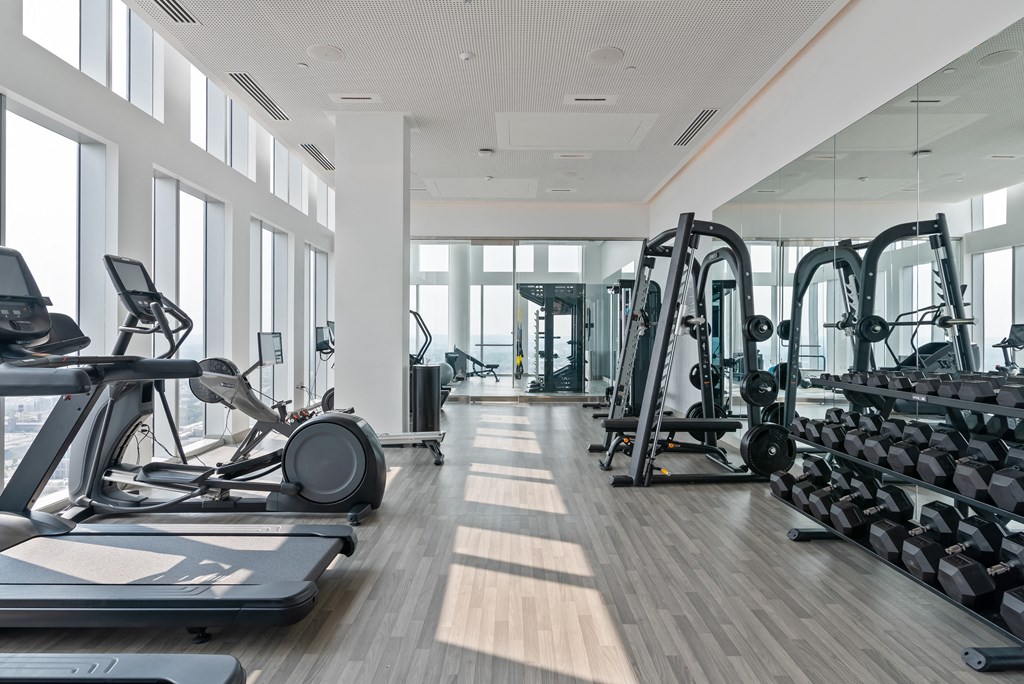 a gym with cardio machines and weights on the floor
