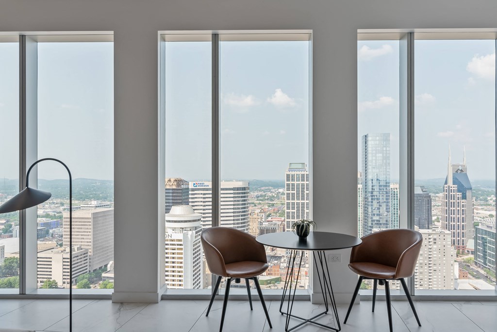 a living room with a table and chairs and a view of the city