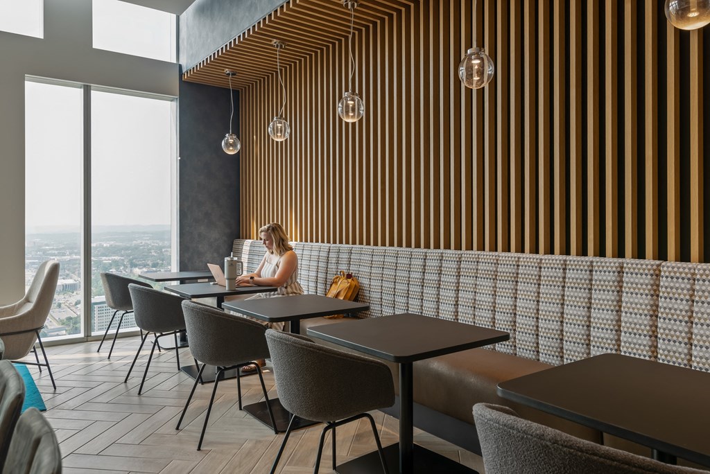 a woman sitting at a table in a restaurant with a laptop