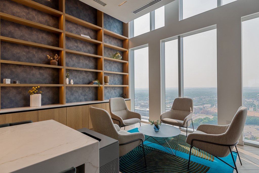 a living room with chairs and a table and a large window