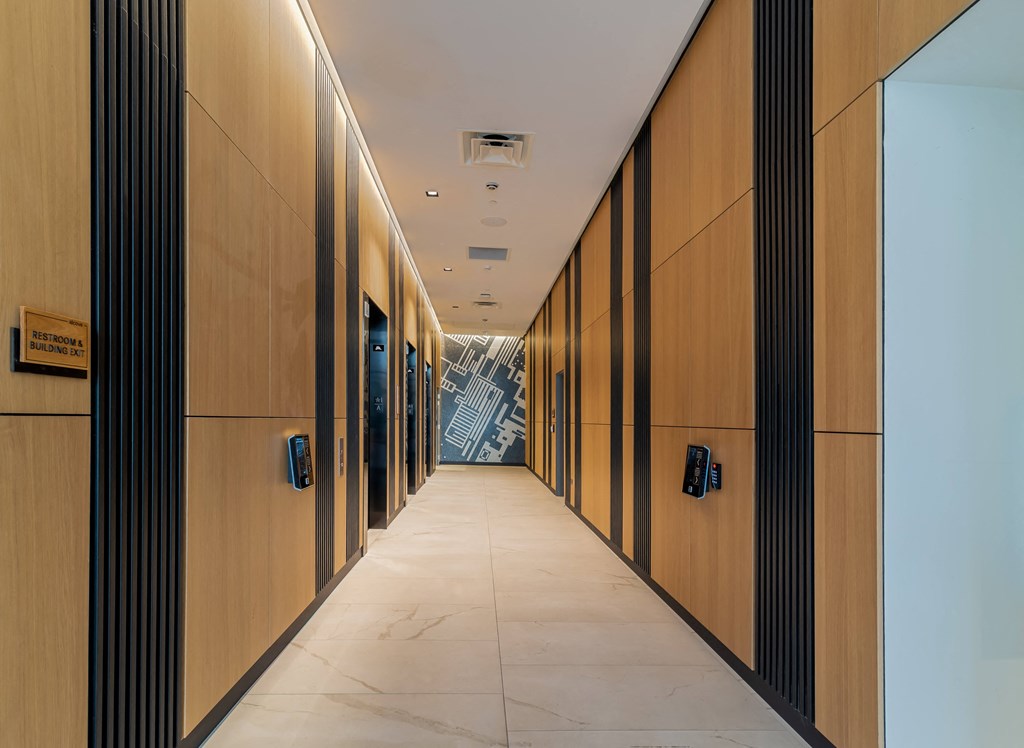 a hallway with rows of wooden cabinets and a white tile floor