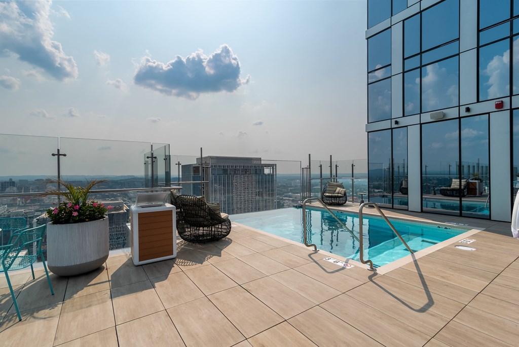 a swimming pool on the roof of a skyscraper overlooking a city