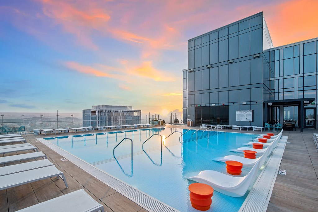 a swimming pool on the roof of a building at sunset