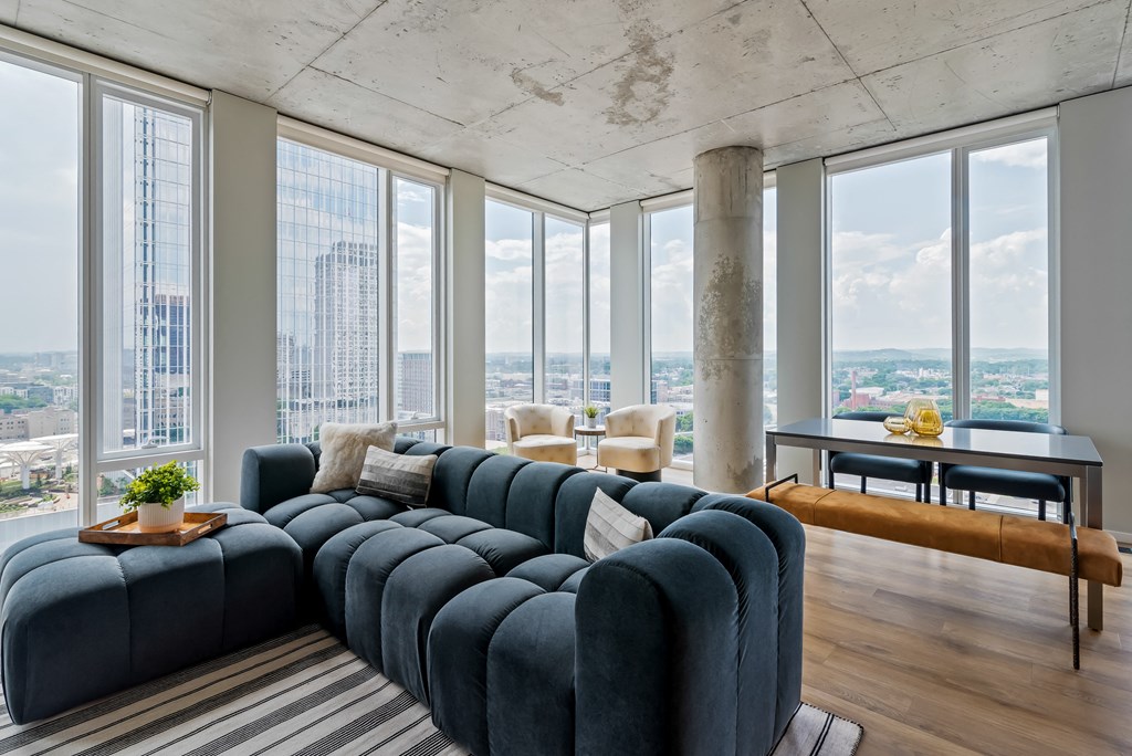 a living room with a blue couch and a view of the city