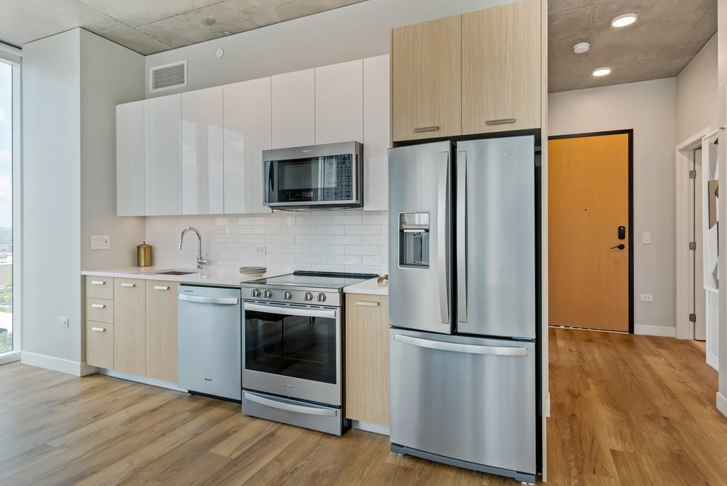 a kitchen with white cabinets and stainless steel appliances and a refrigerator