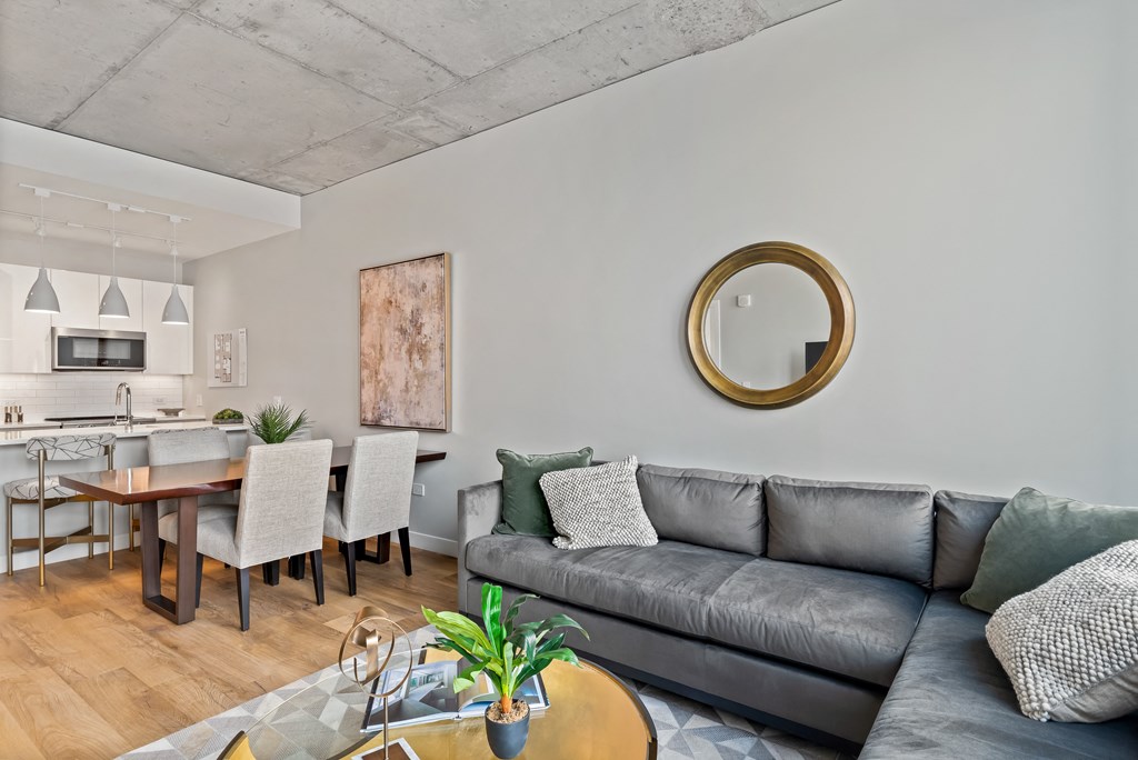 a living room with a couch and a table and a kitchen with a dining room