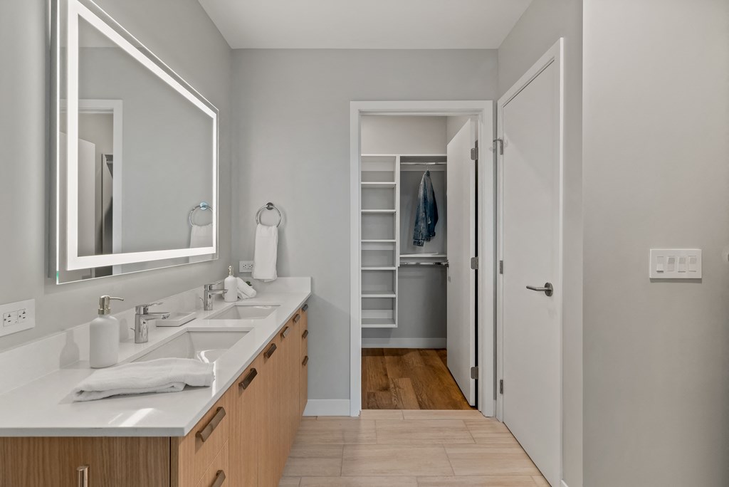 a bathroom with two sinks and a mirror and a closet