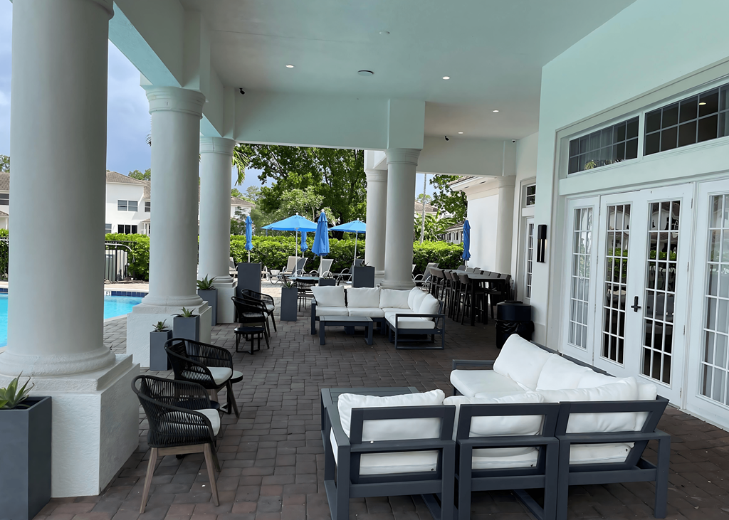 a patio with chairs and tables and a pool