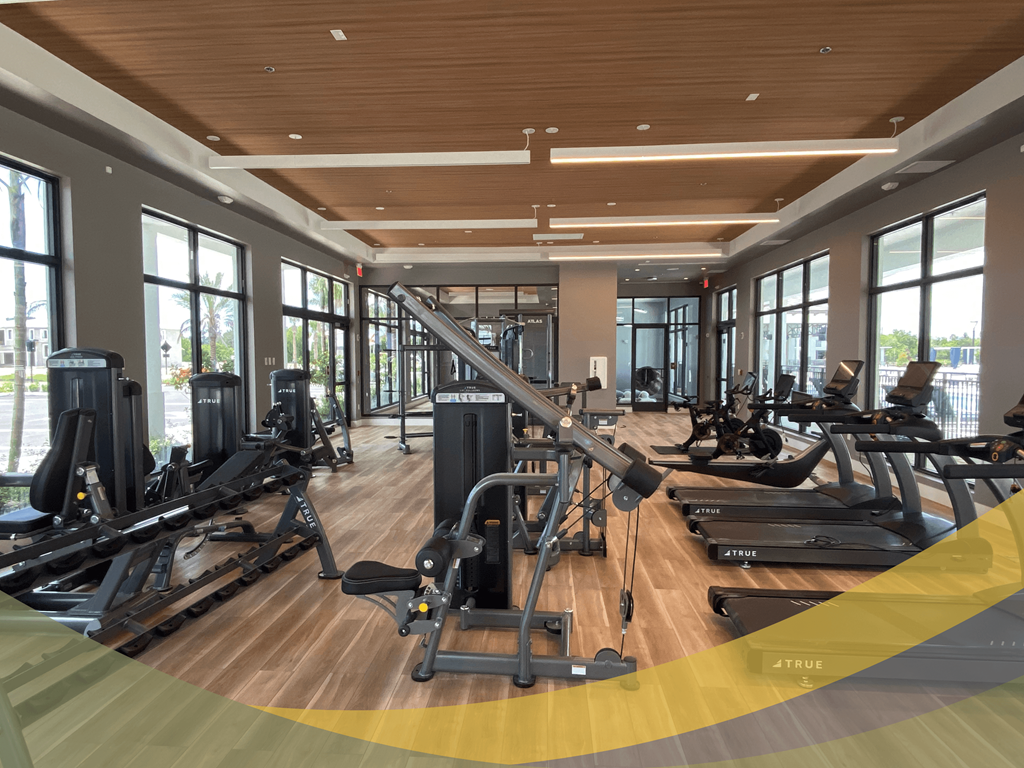 a gym with cardio equipment and windows in a building