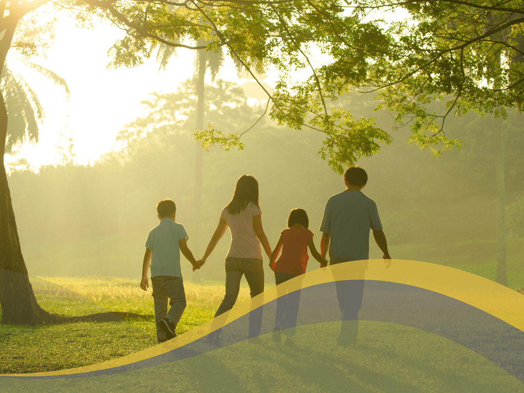 a family holding hands while walking through a park
