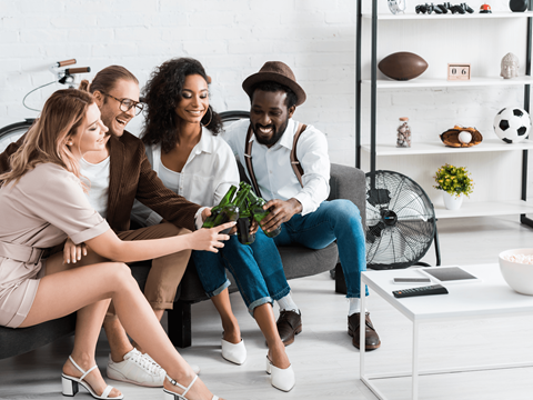 Four people sitting on a couch in a living room.