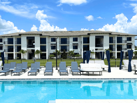 A poolside area with lounge chairs and a table.
