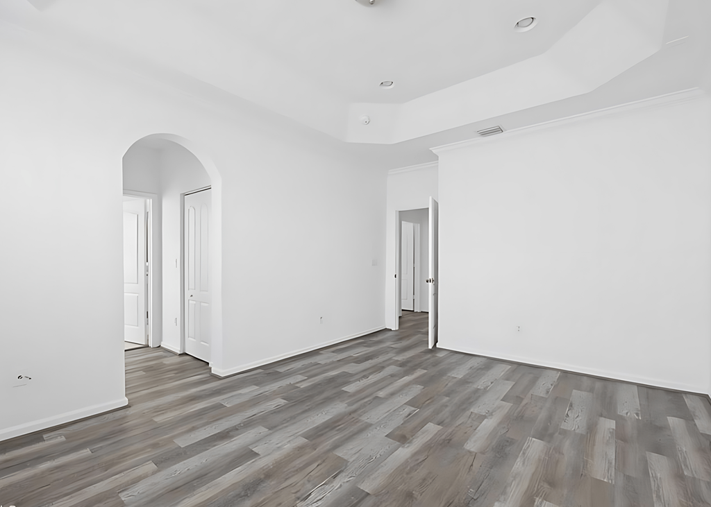 an empty living room with white walls and wood flooring