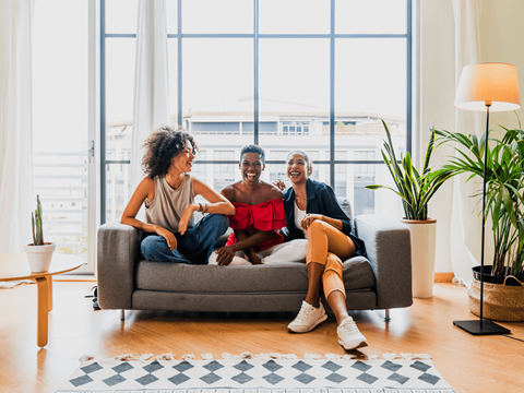 three people sitting on a couch in a living room at The Orchard at Portofino Vineyards, Fort Myers Florida