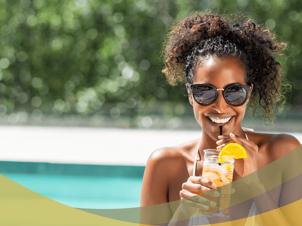 a woman sitting in a pool drinking a cocktail