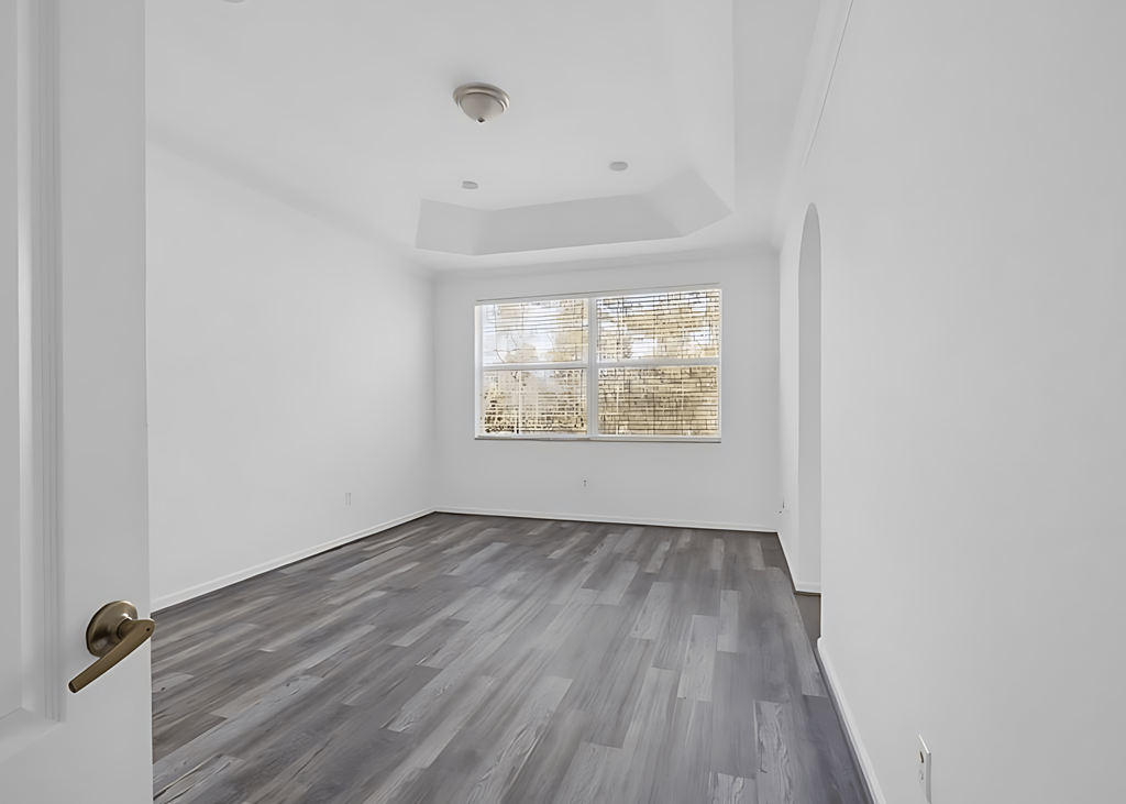 an empty living room with white walls and a window