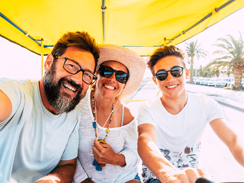 a group of three people sitting under a yellow tent