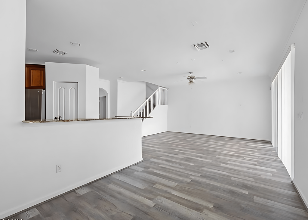 an empty living room with white walls and wood floors