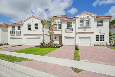 a large white house with two palm trees in front of it