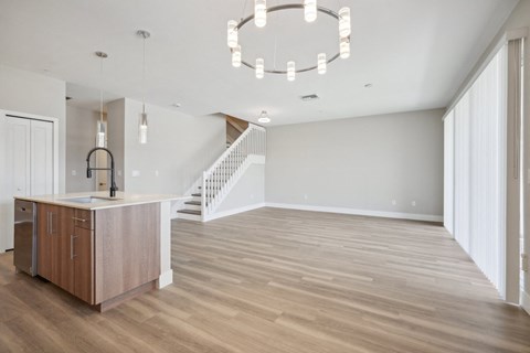 a living room with a kitchen and a staircase