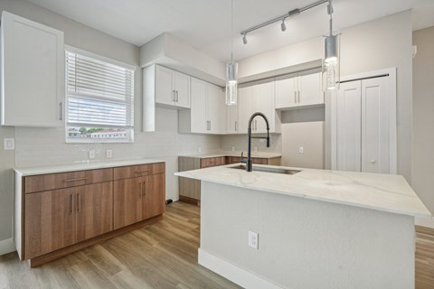 an open kitchen with a large counter top and a sink
