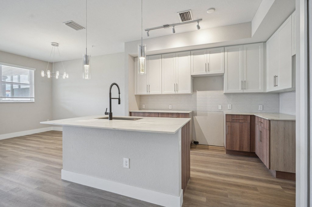 a kitchen with white cabinets and a large white counter top