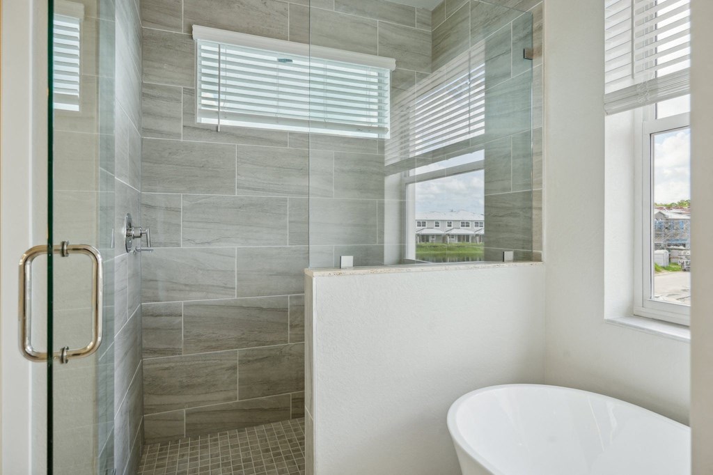 a bathroom with a tub and a shower and a window