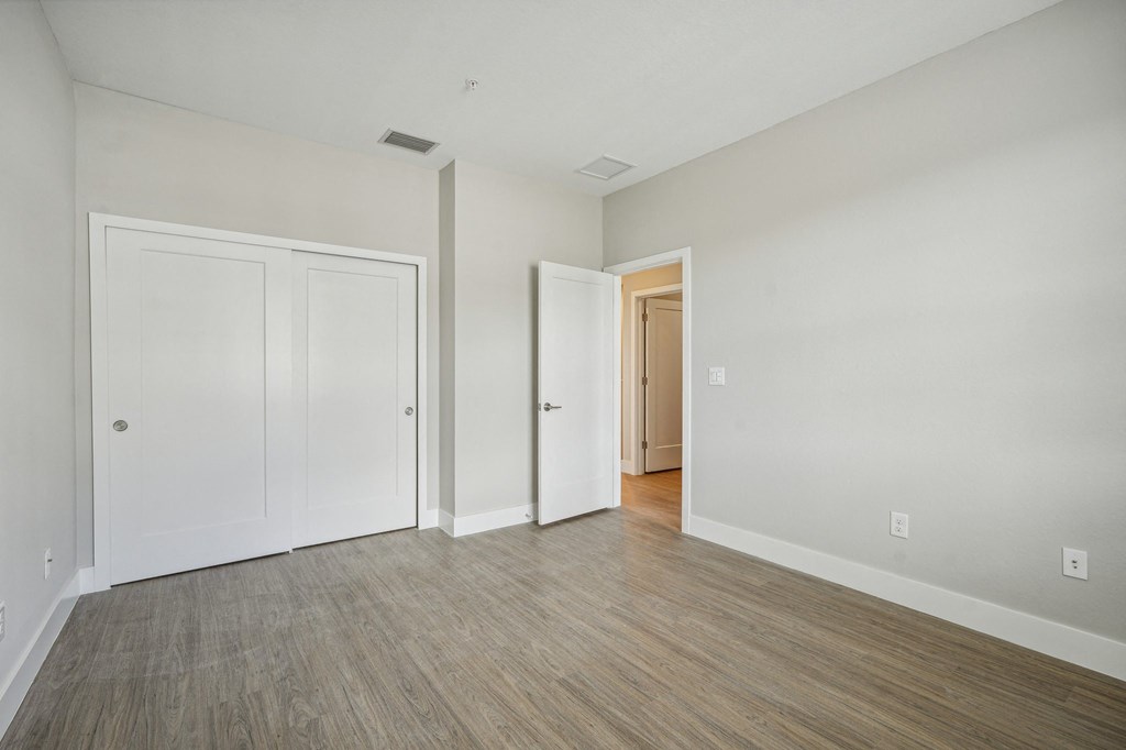 an empty living room with white walls and wood flooring