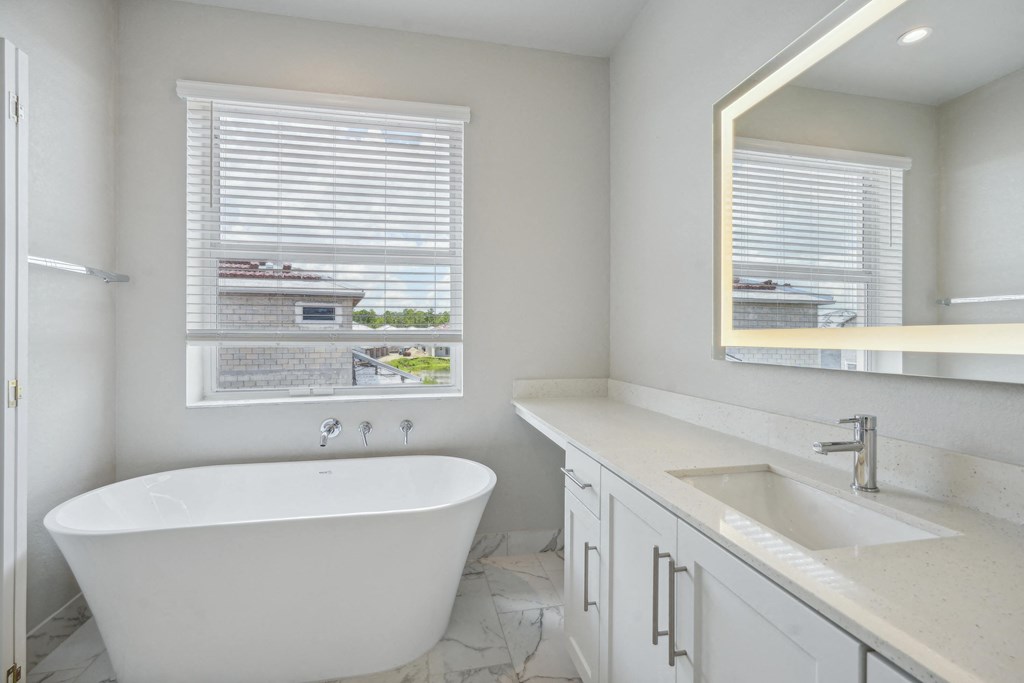a bathroom with a tub and a sink and a window at The Falls of Portofino Apartment, Florida, 34119