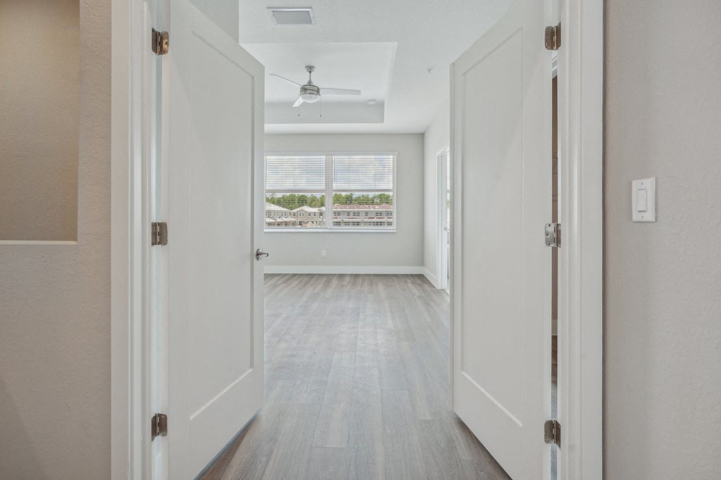 an empty living room with white walls and a window