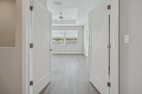 an empty living room with white walls and a window