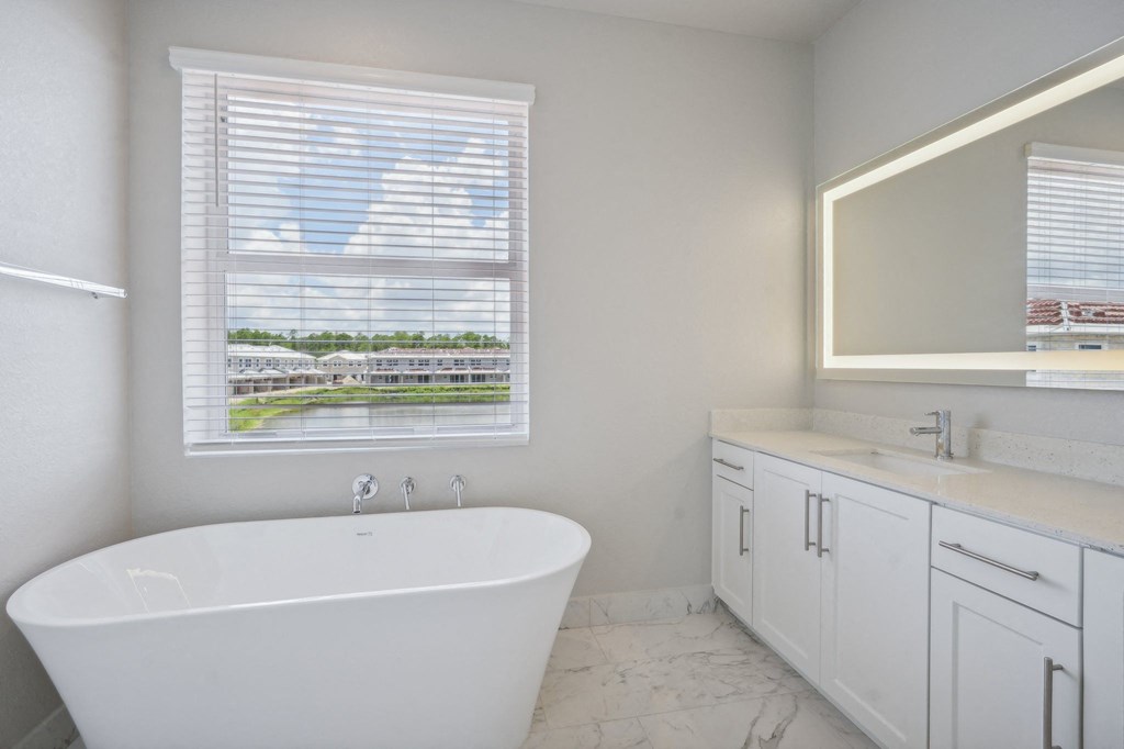 a bathroom with a tub and a window and a sink