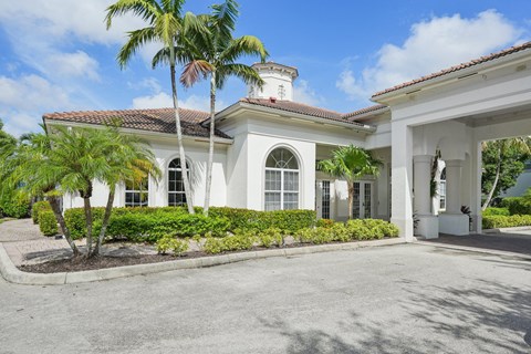 the front of a white building with palm trees