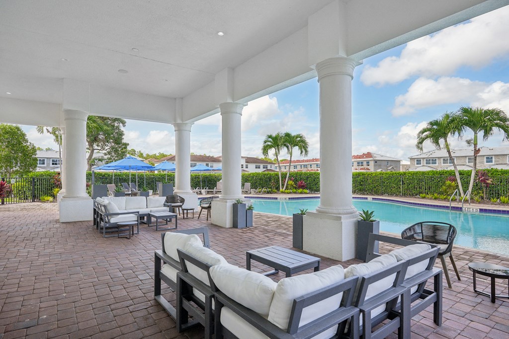 A patio with a pool and chairs at The Falls of Portofino Apartment, Naples, 34119